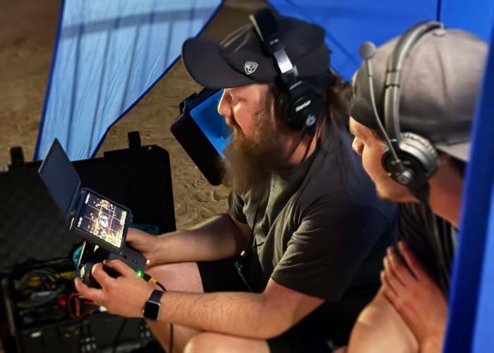 Drone pilot operators operating drone and fpv at live sporting event or concert